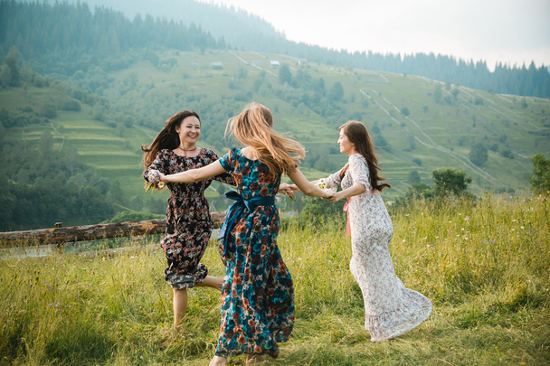 Chicas vestidos de novia descansan en la naturaleza en un hermoso prado de montaña
 - Foto, imagen