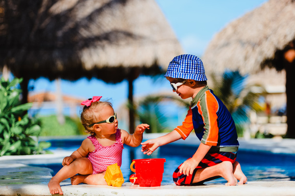 Kleiner Junge und kleines Mädchen spielen am Strand - Foto, Bild