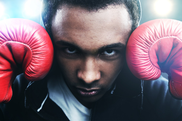 Close up of African American boxer holding his hands near the head and looking at the viewer. Concept of sports - Фото, изображение