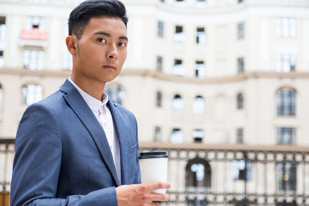 Asian businessman drinking his coffee - Foto, afbeelding