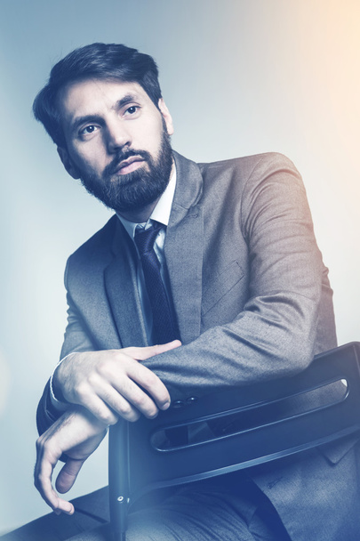Businessman with elbow placed on chair back - Fotoğraf, Görsel