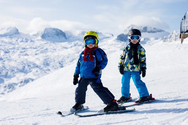 Dos niños pequeños, hermanos hermanos, esquiando en la montaña austriaca
 - Foto, Imagen