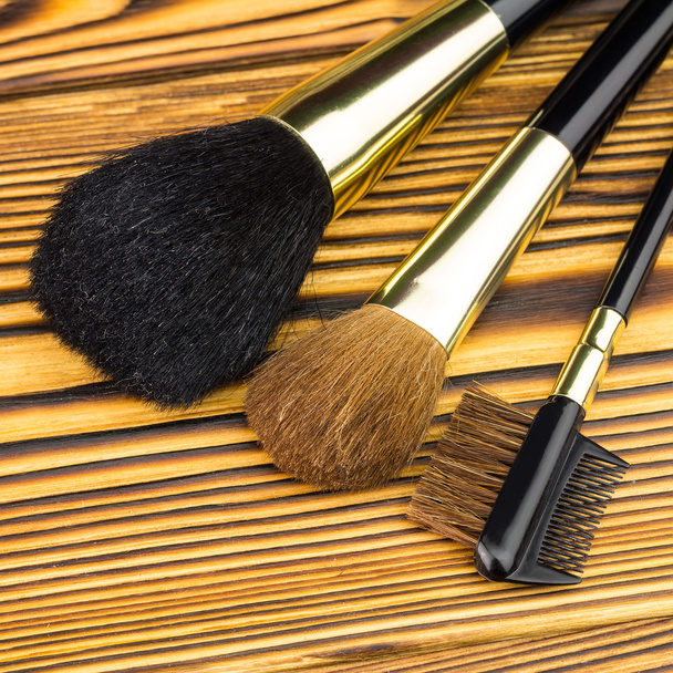 Profesjonalne szczotki kosmetyczne makijaż na podłoże drewniane. - Zdjęcie, obraz