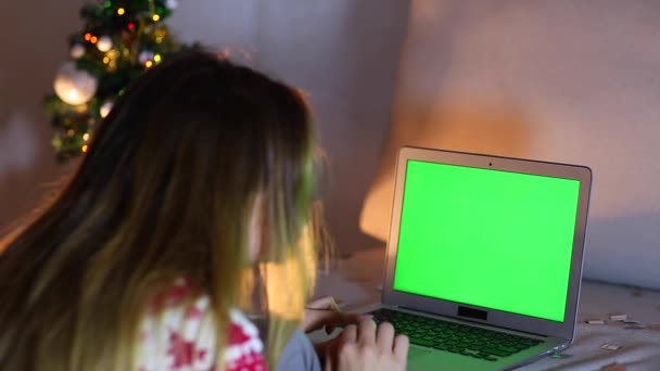 Toque de imprensa mão da mulher tela verde no teclado do laptop, luzes Bokeh fundo da árvore de Natal na noite
. - Filmagem, Vídeo