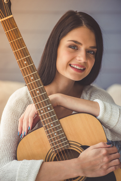 Houkutteleva tyttö soittaa kitaraa
 - Valokuva, kuva