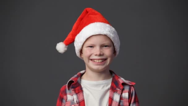 Close up cute little boy in xmas cap smiling - Imágenes, Vídeo