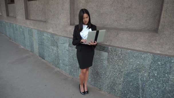 Młody biznes dama dziewczynka kobiece kobieta portret trzymać użycie naciśnij przycisk klawiatury laptopa na tle budynku biurowego odkryty - Materiał filmowy, wideo