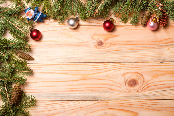 Corner frame of fir branches with Christmas decorations on a light wooden background - Foto, Imagem