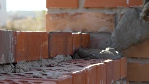 Rękami budowniczego umieścić zaprawy cementowej. Ręka sprawia, że mur z cegły. - Materiał filmowy, wideo
