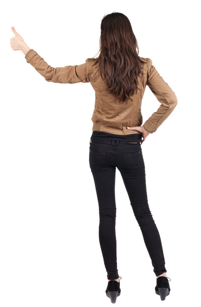 Back view of of beautiful brunette woman in brown jacket makes - Foto, imagen