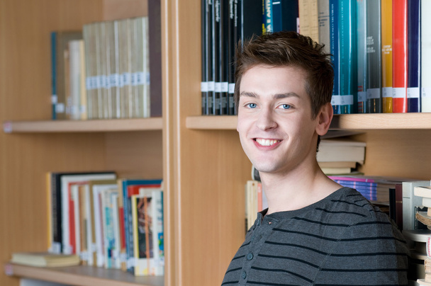Happy student in a library - Valokuva, kuva