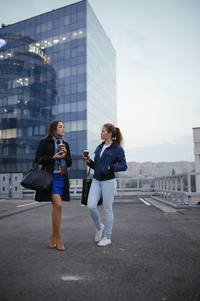 Two joyful women friends walking in city and speaking - Valokuva, kuva