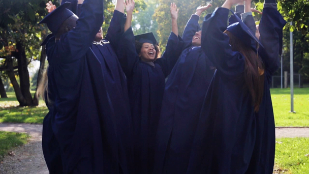 estudantes felizes em placas de argamassa com as mãos no topo
 - Filmagem, Vídeo