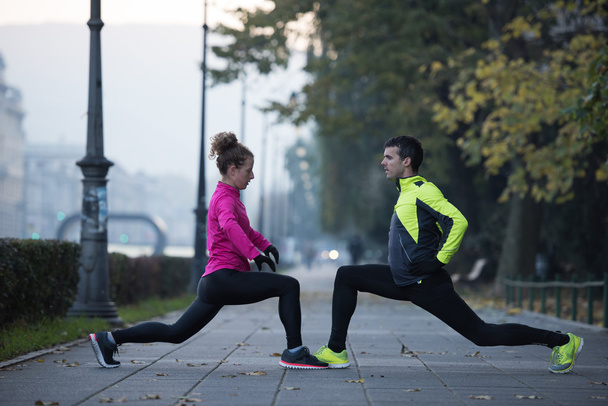 couple warming up before jogging - Foto, afbeelding
