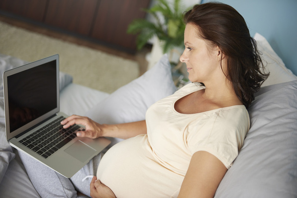 pregnant woman using digital device - Фото, изображение
