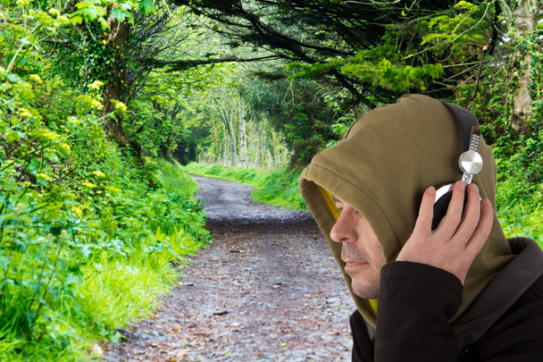 Man in hoodie listening to headphones - Photo, Image