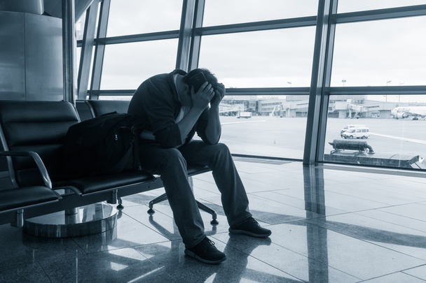 Λυπημένος άνθρωπος αναμονή για καθυστερημένη πτήση - Φωτογραφία, εικόνα