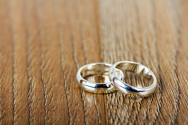 pár snubních prstenů na dřevěné pozadí - Fotografie, Obrázek