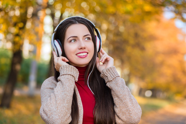 woman with headphones in autumn park - Zdjęcie, obraz