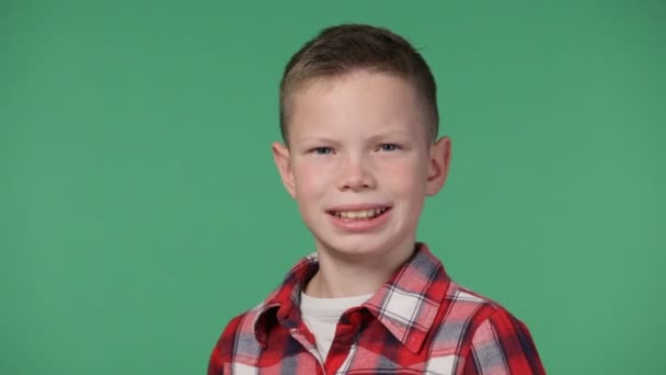 Litle ładny chłopiec uśmiecha się z bliska - Materiał filmowy, wideo