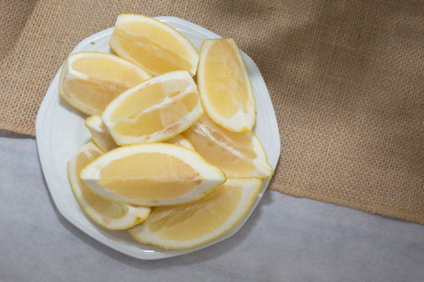 Un montón de rodajas, limón en un plato en una mesa
 - Foto, Imagen