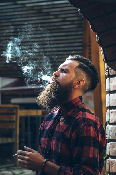 Adult man exhaling cigarette smoke - Foto, Imagen