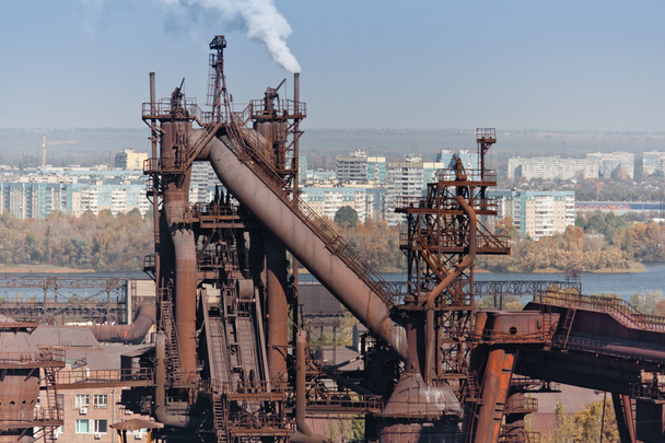 Industrielandschaft mit Hüttenwerk. Stadt im Hintergrund - Foto, Bild