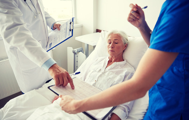 médico y enfermera visitando a una mujer mayor en el hospital
 - Foto, Imagen