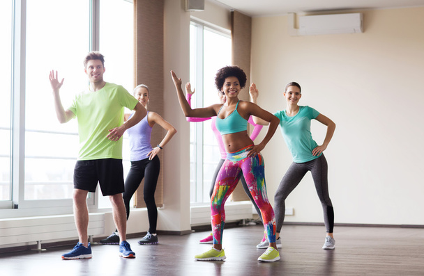 group of smiling people dancing in gym or studio - Photo, Image