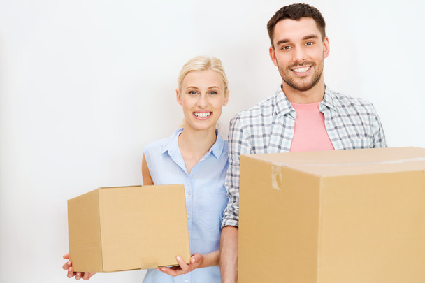 couple with cardboard boxes moving to new home - Photo, Image