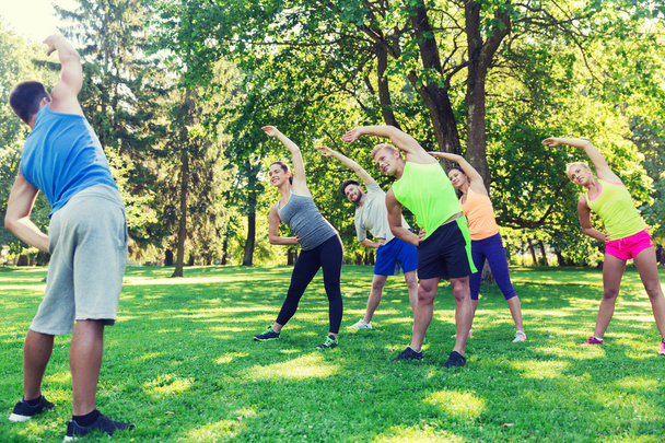 group of friends or sportsmen exercising outdoors - Fotó, kép