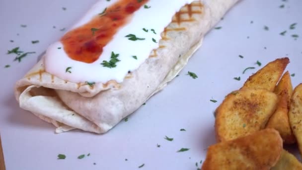 Tortilla-Wraps mit frischen Zutaten auf einem hölzernen Hintergrund, Drehschuss - Filmmaterial, Video