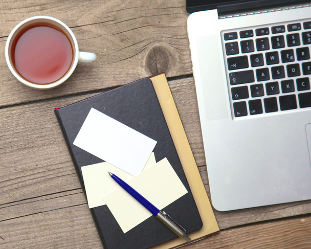 Порожні візитки з ручкою, ноутбуком та чашкою чаю на дерев'яному офісному столі
 - Фото, зображення