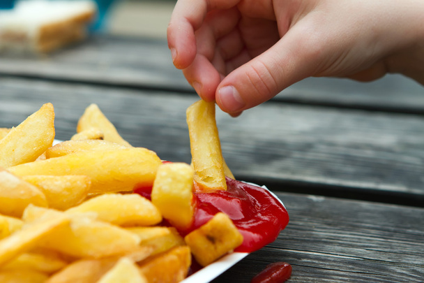 child dipping a chip into tomato sauce - Photo, Image