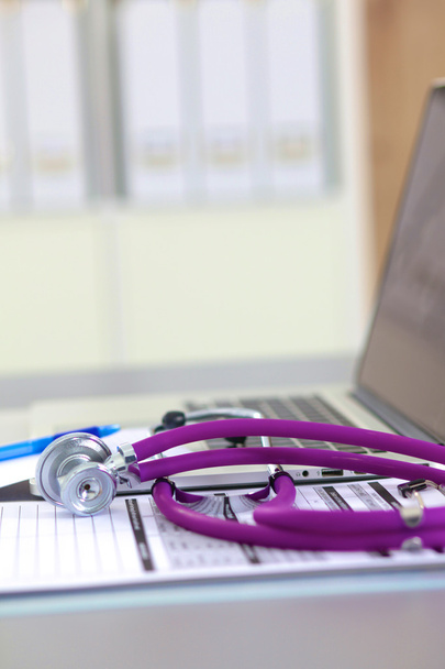 medizinisches Stethoskop neben Laptop auf Holztisch, weiß - Foto, Bild