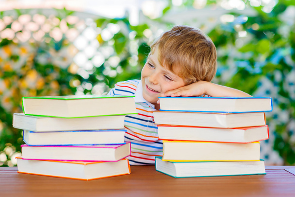 Little kid boy reading book at school - Photo, Image