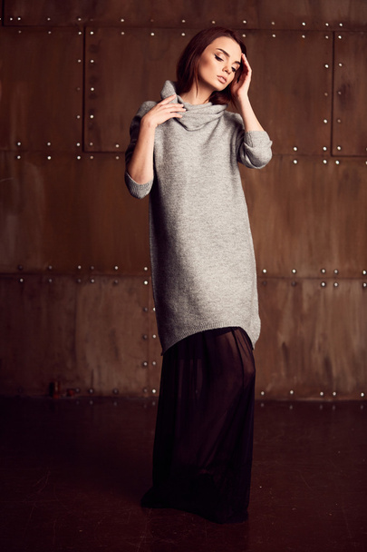 Pretty model posing in studio in grey dress - Foto, Imagen