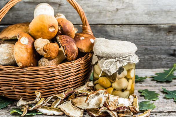 Autumnal mushrooms preserves, dry mushroom and  boletus marinated in jar on wooden table - Foto, imagen