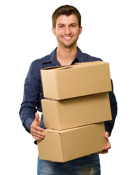 een jonge man met een stapel van kartonnen dozen - Foto, afbeelding