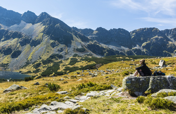 Zakopane, Poland - September 08, 2016: Girl sitting on a rock in the valley and admire the mountain - Photo, image