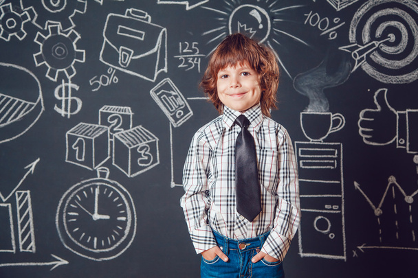 Little boy as businessman or teacher wearing shirt and tie on a dark background with business school picture - Photo, image