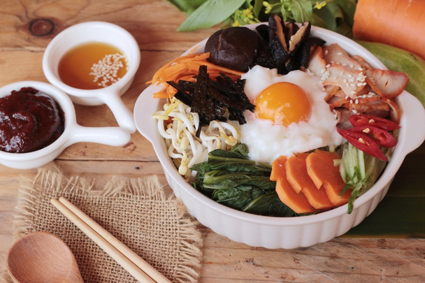 Ahşap arka plan üzerinde Bibimbap Kore gıda lezzetlidir - Fotoğraf, Görsel