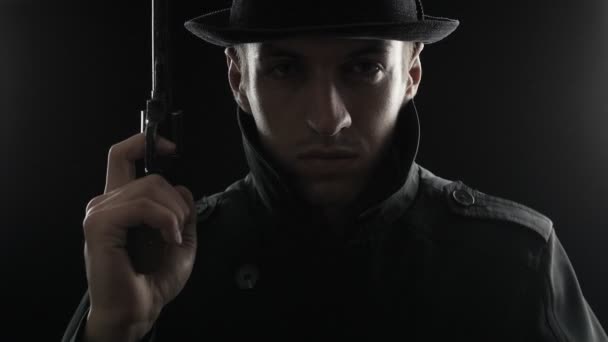 Portréja egy gengszter egy kalap és egy fekete köpenyt, egy fegyverrel a kezében - Felvétel, videó