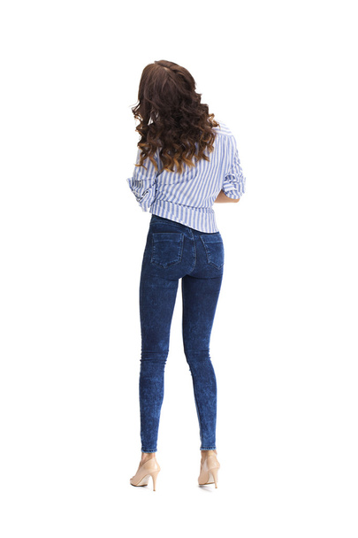 Young beautiful brunette woman in blue jeans  - 写真・画像