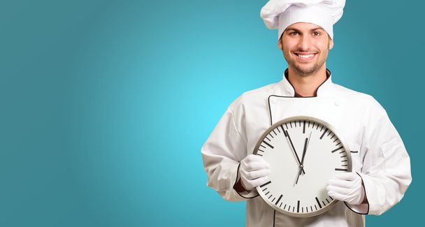 Шеф-повар держит настенные часы
 - Фото, изображение