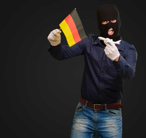 Man wearing a robber mask and holding airplane miniature and fla - Photo, Image