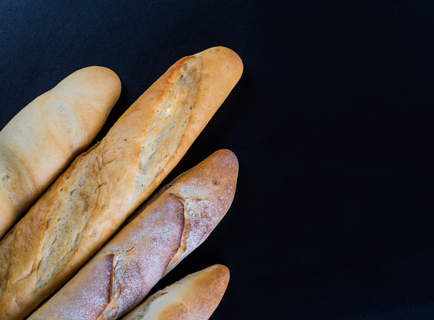Assortment of baked bread on wooden table background - Fotoğraf, Görsel