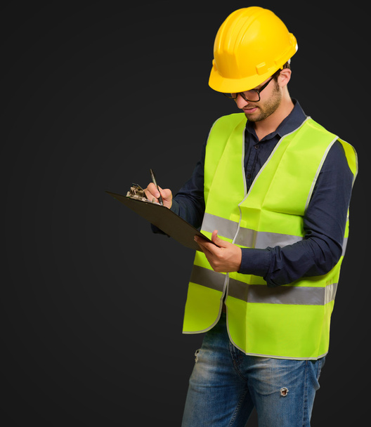 A Young Engineer Holding A Clipboard And Writing - Photo, Image
