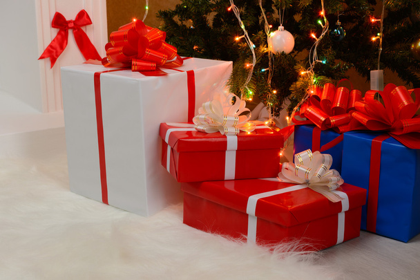 Christmas gifts by the fireplace and fir-tree - Photo, Image