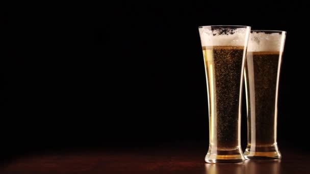 pivo do sklenic na černou a dřevěný stůl - Záběry, video